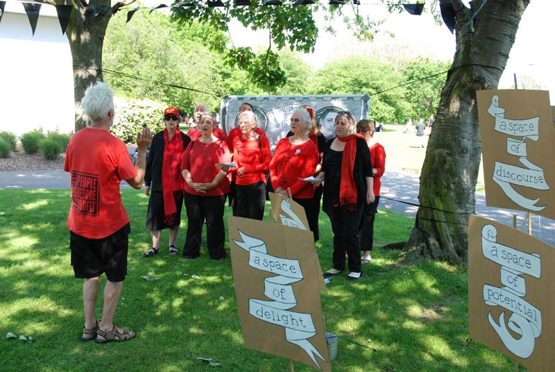 The Strawberry Thieves Choir, with placards, banner and bunting by Rachael House
